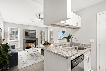 A modern kitchen with a fireplace and a blue sofa.